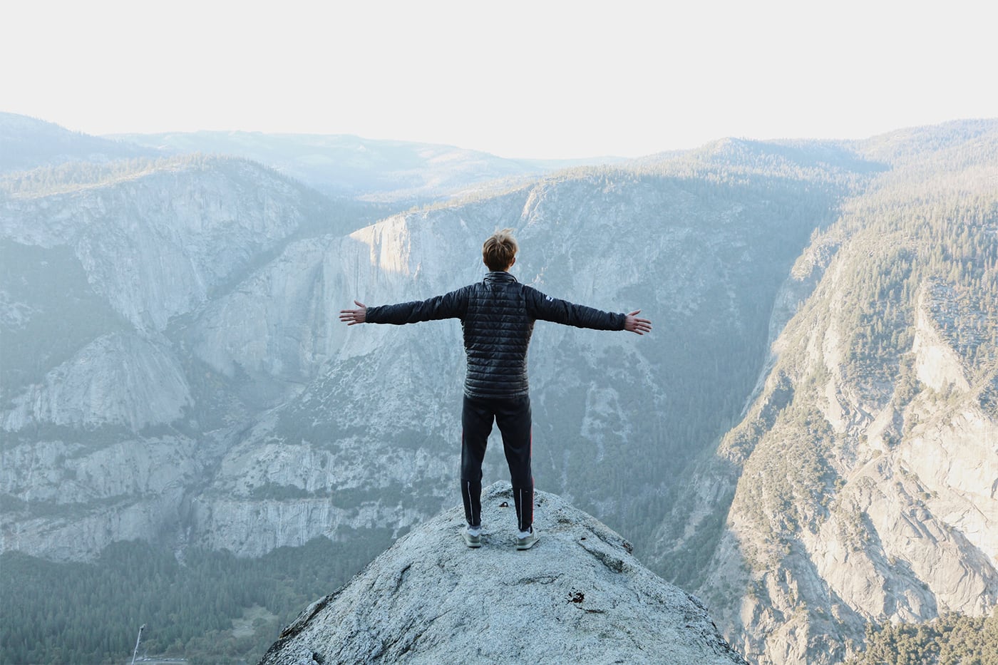 man standing on peak of mountain
