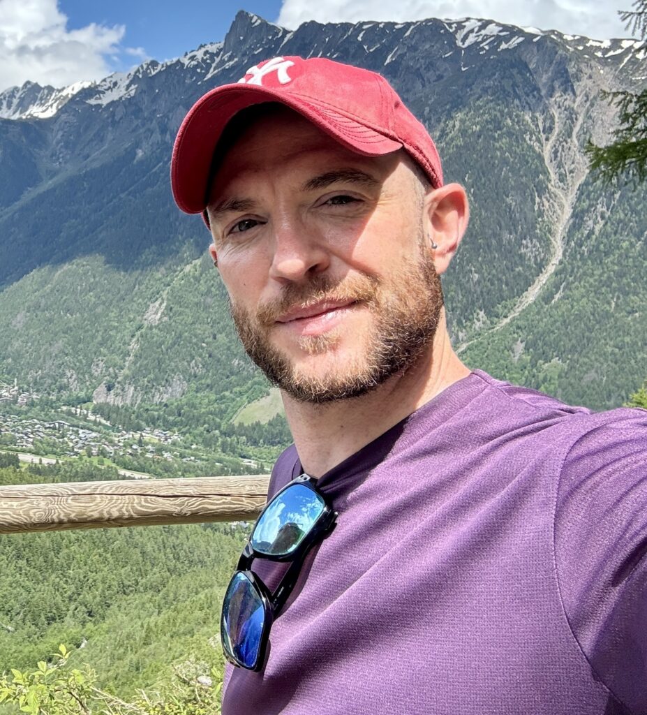 Dave facing left in a red cap in the Alps